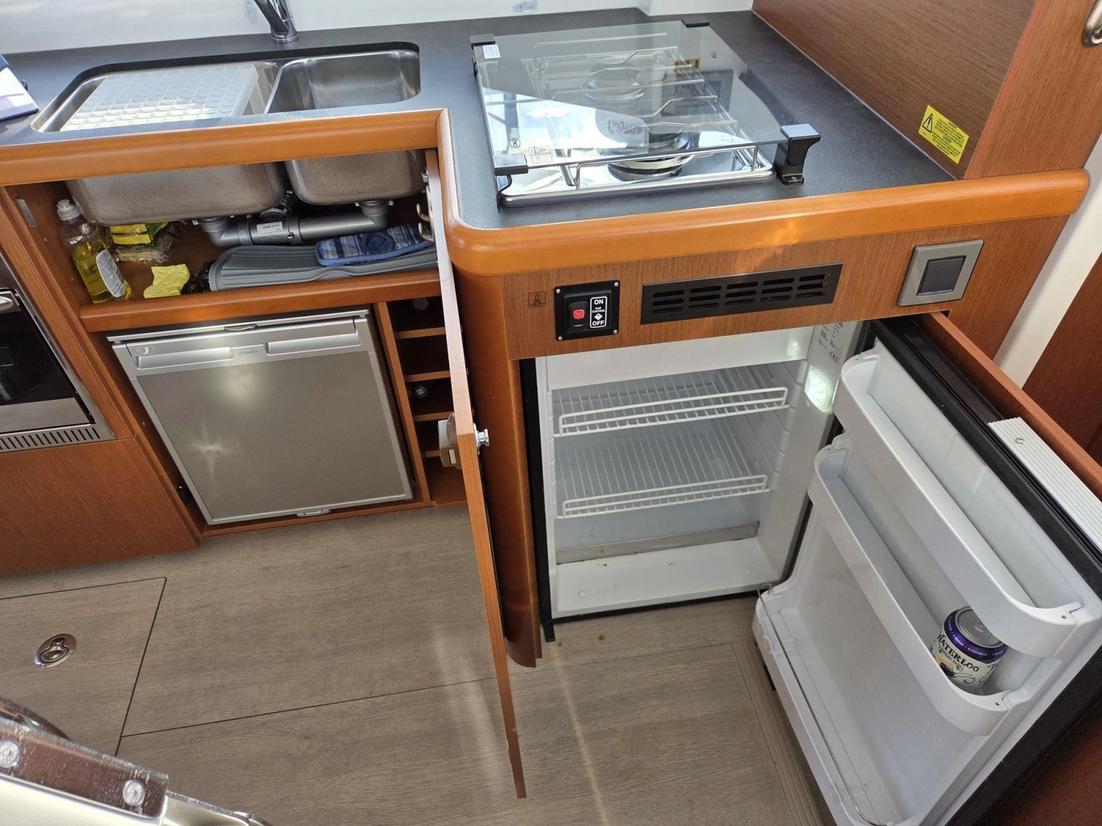 Galley showing main fridge (open) and additional under-sink fridge/freezer