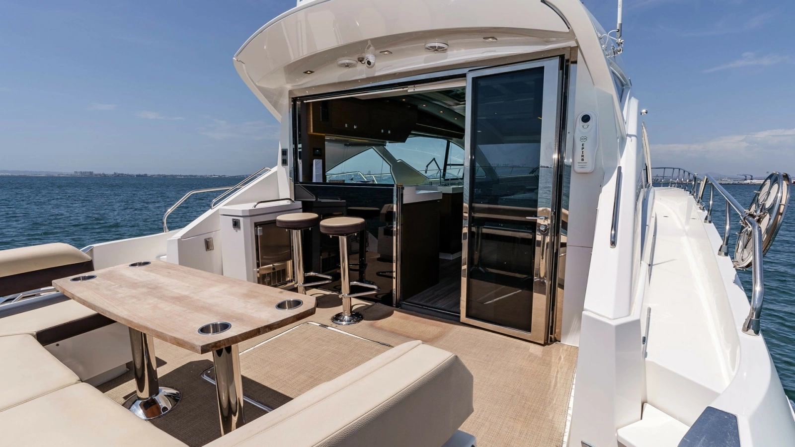 2017 Cruisers 60 Cantius, 'Rising Star' - Features a Luxurious Seating Area with a Sleek, Modern Table Perfect for Entertaining. The Seamless Transition to the Interior is Facilitated by Large Sliding Glass Doors, Opening up to a Stylish Bar with High Sto