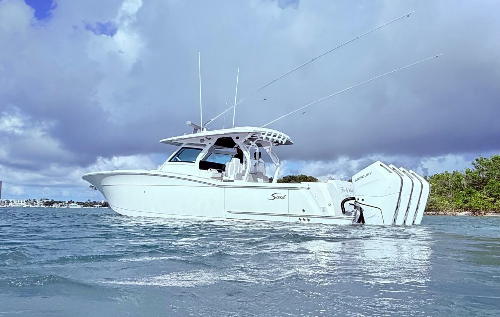 2024 Scout 400 LXF boat on water with triple Mercury engines