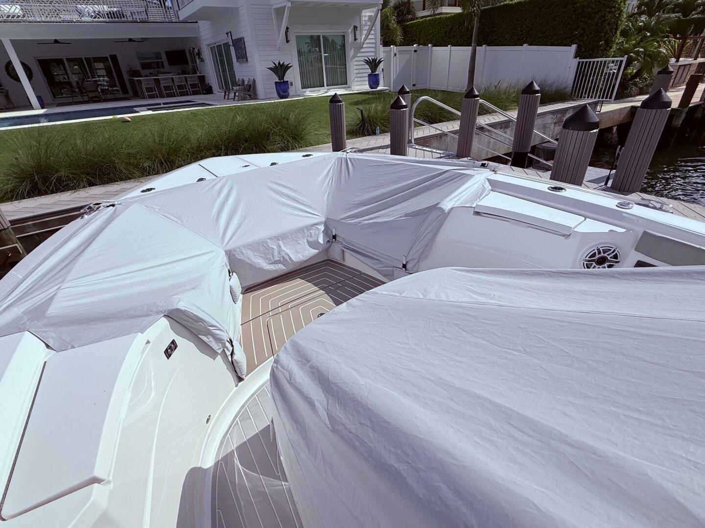 2024 Scout 400 LXF boat covered at dockside near modern wate