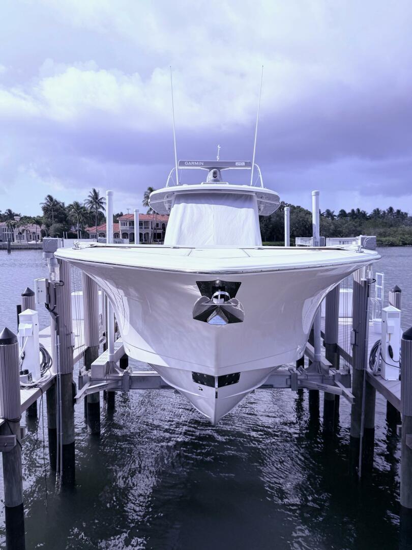 2024 Scout 400 LXF boat docked, front view with water and cl
