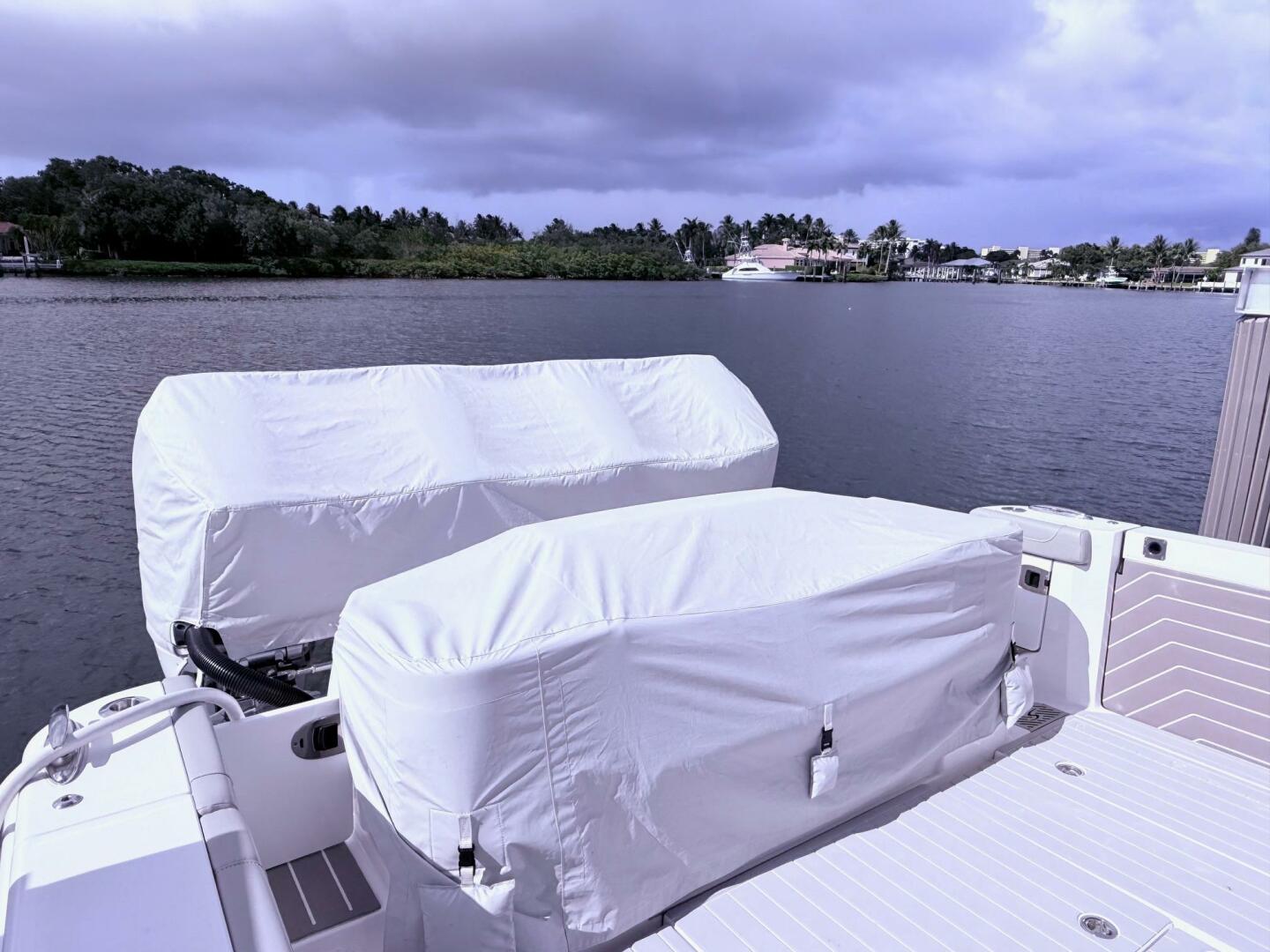 2024 Scout 400 LXF boat with covered engines docked by a sce