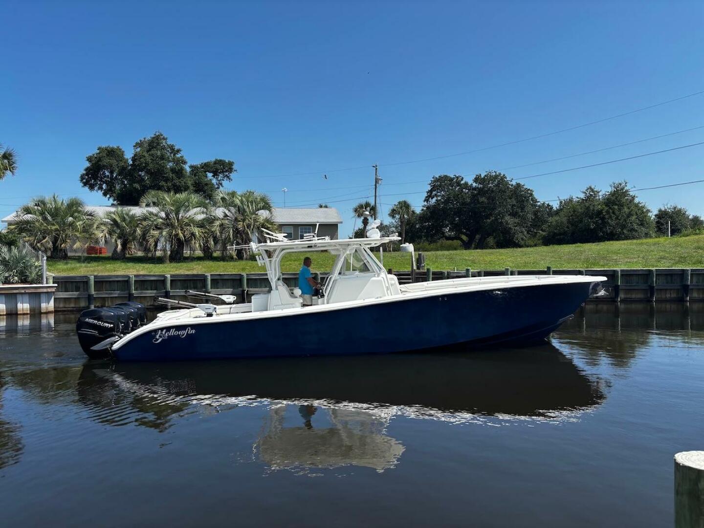 2015 Yellowfin 39 boat on calm water, clear sky, and lush gr