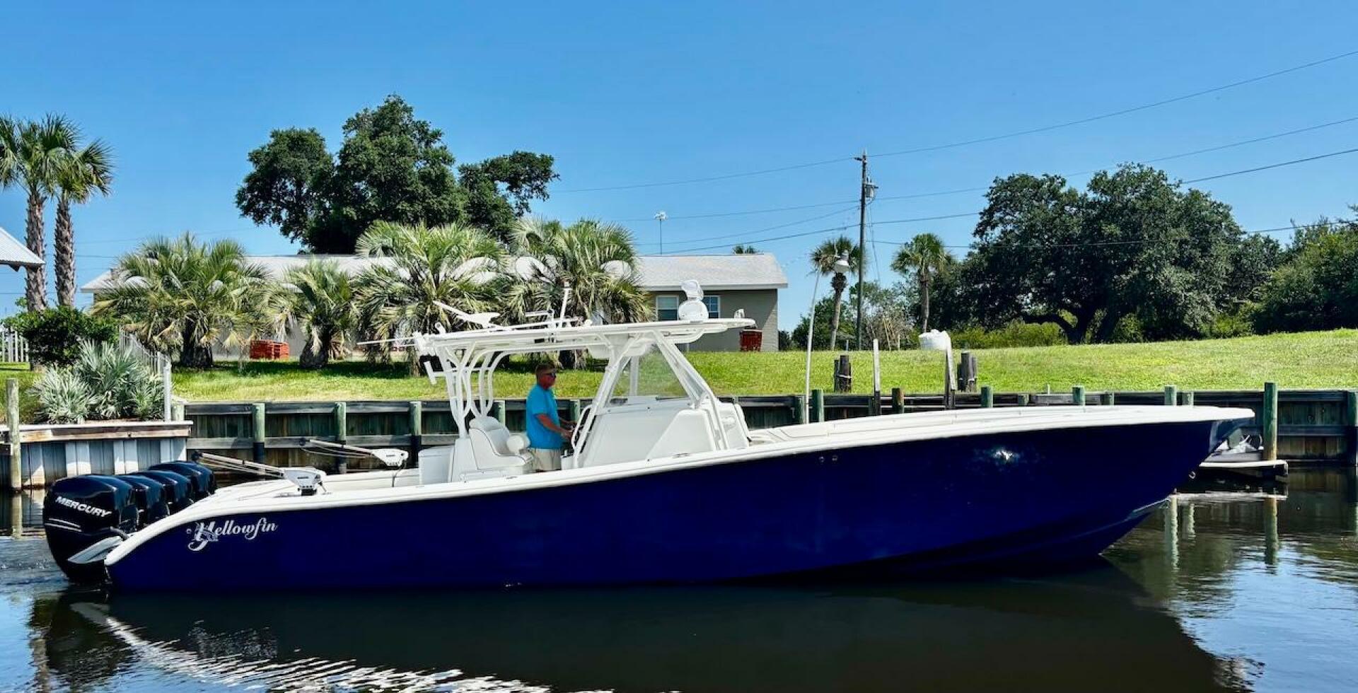 2015 Yellowfin 39 boat docked near lush greenery and palm tr