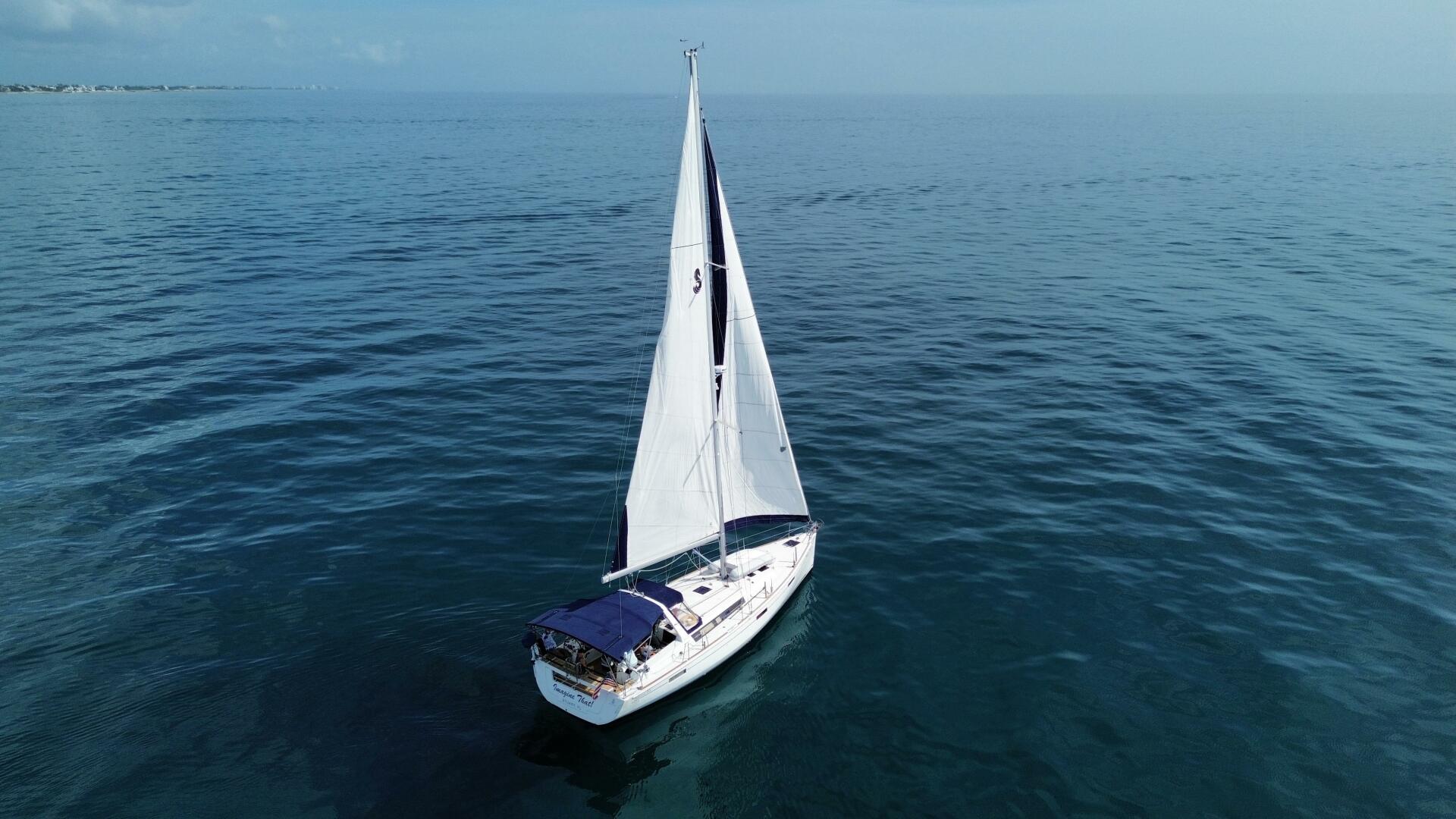 2015 Beneteau Oceanis 45 sailing on calm blue ocean waters.