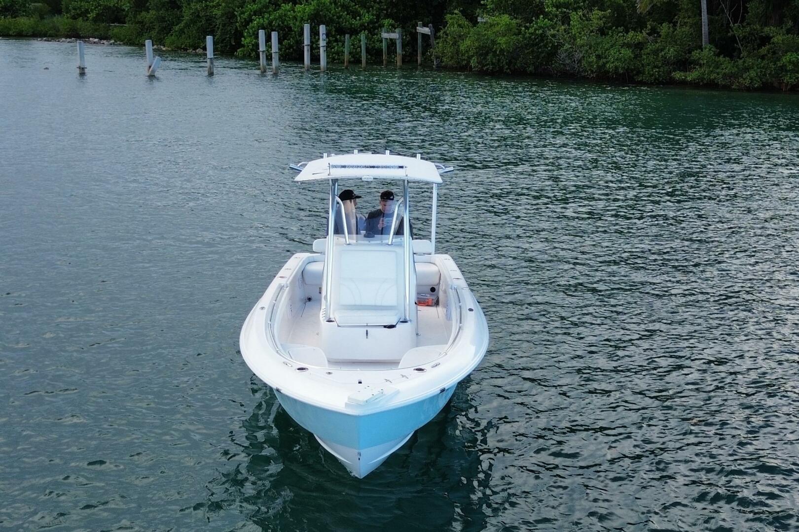 2023 Contender 24 Sport boat on calm water, surrounded by lu
