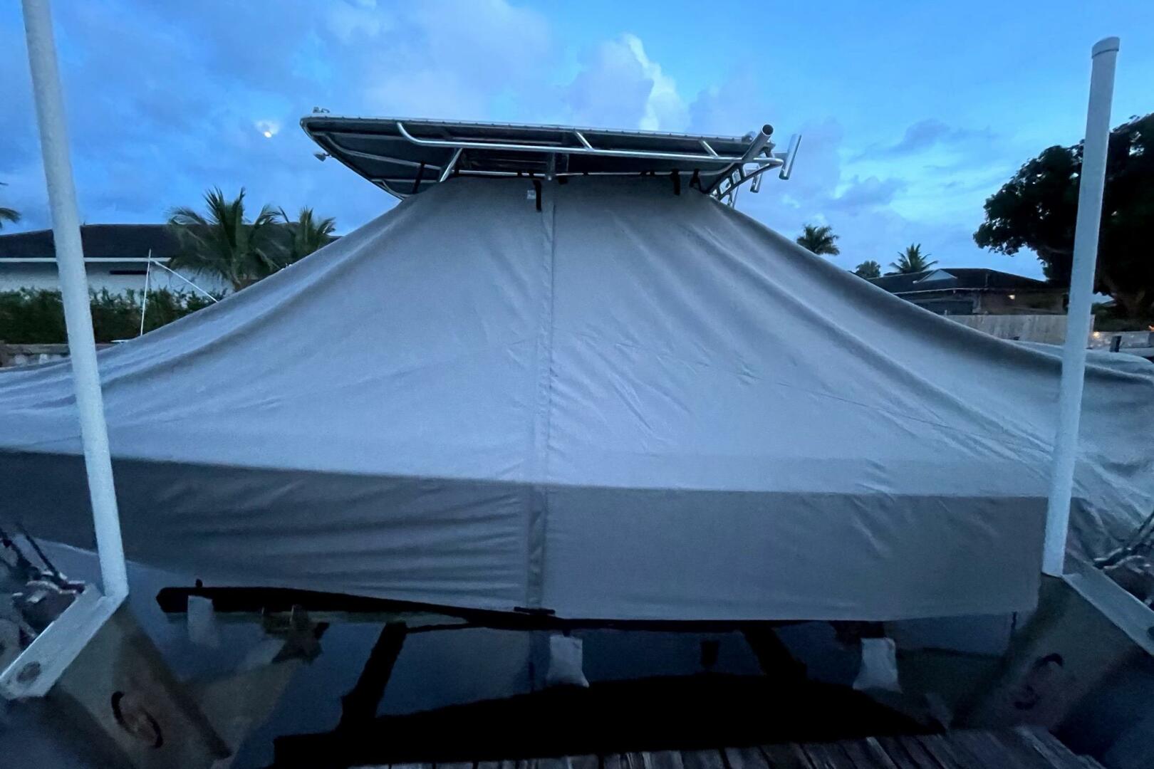 2023 Contender 24 Sport boat covered at dock during twilight