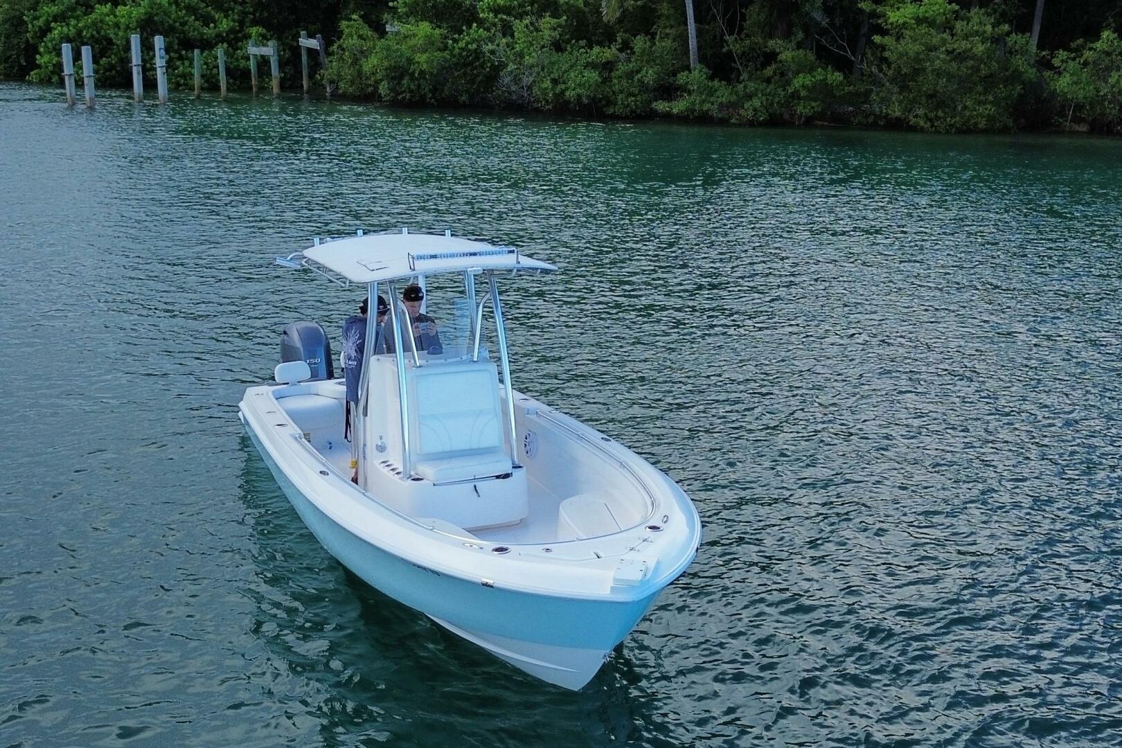 2023 Contender 24 Sport boat on calm water, surrounded by lu