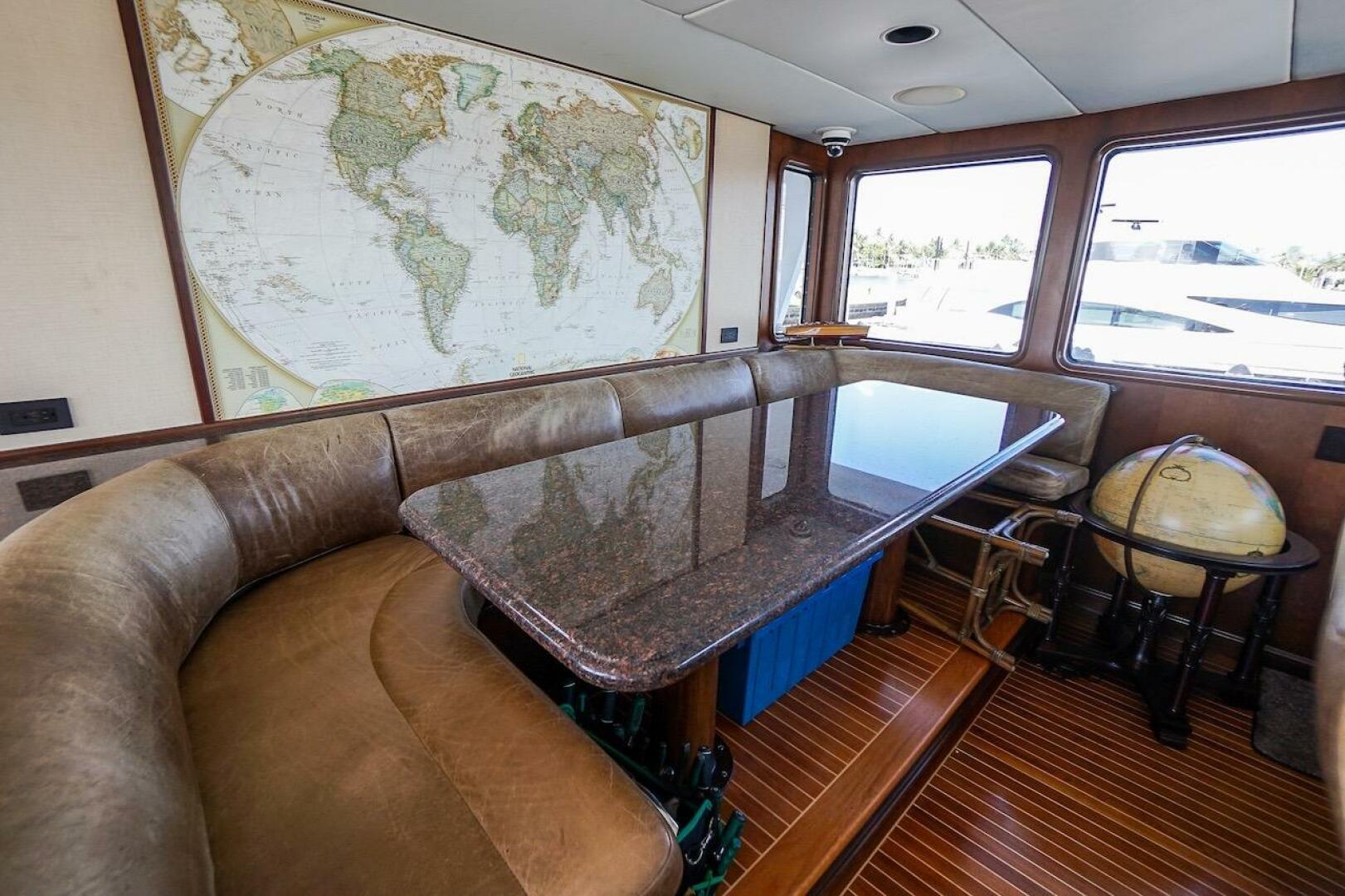 Luxury yacht deck with three white chairs, overlooking marin