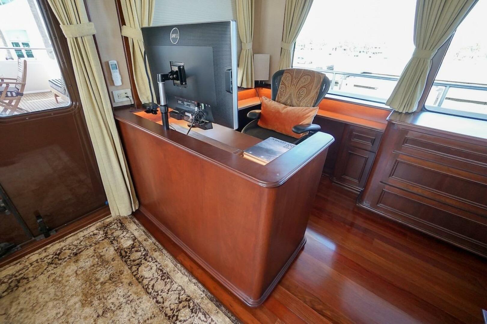 Luxurious yacht interior with wooden desk, monitor, and eleg