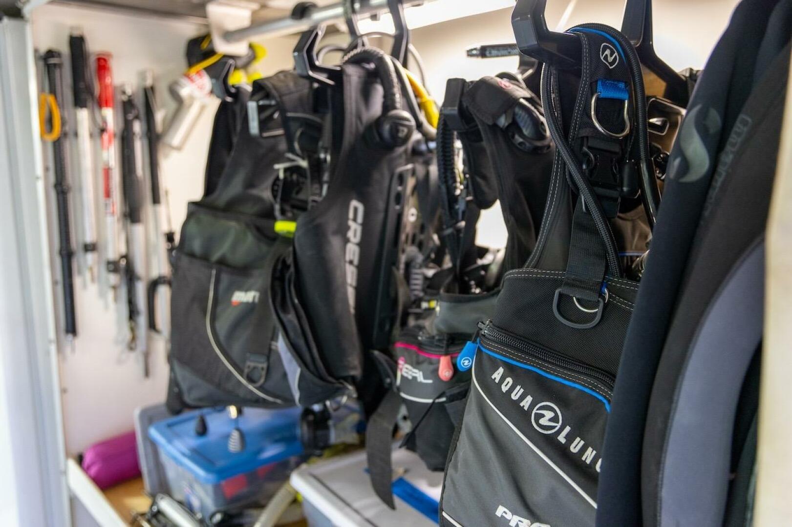 Diving gear storage with wetsuits and equipment in a well-or