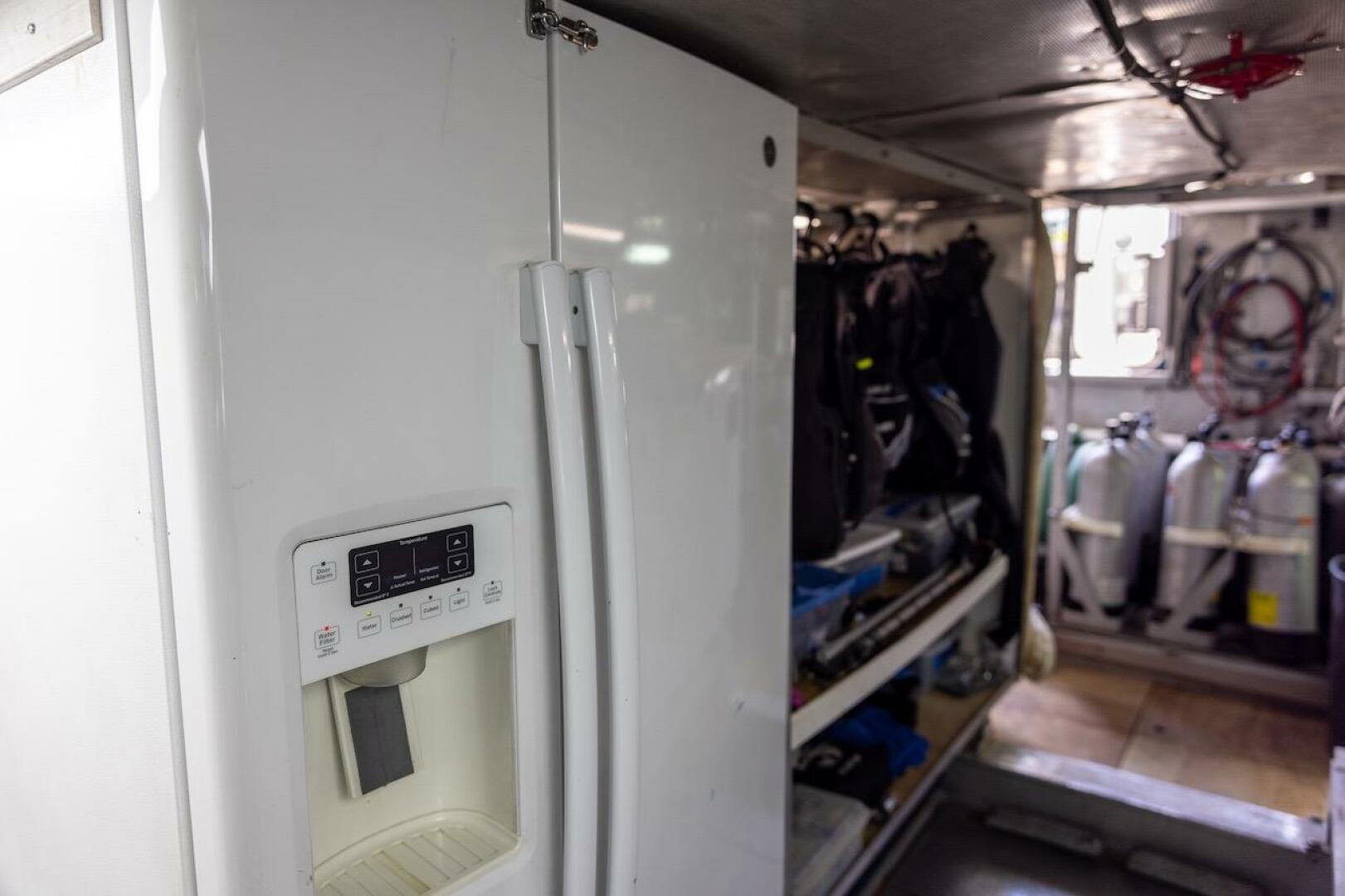Refrigerator in a storage area with scuba gear and tanks, AB