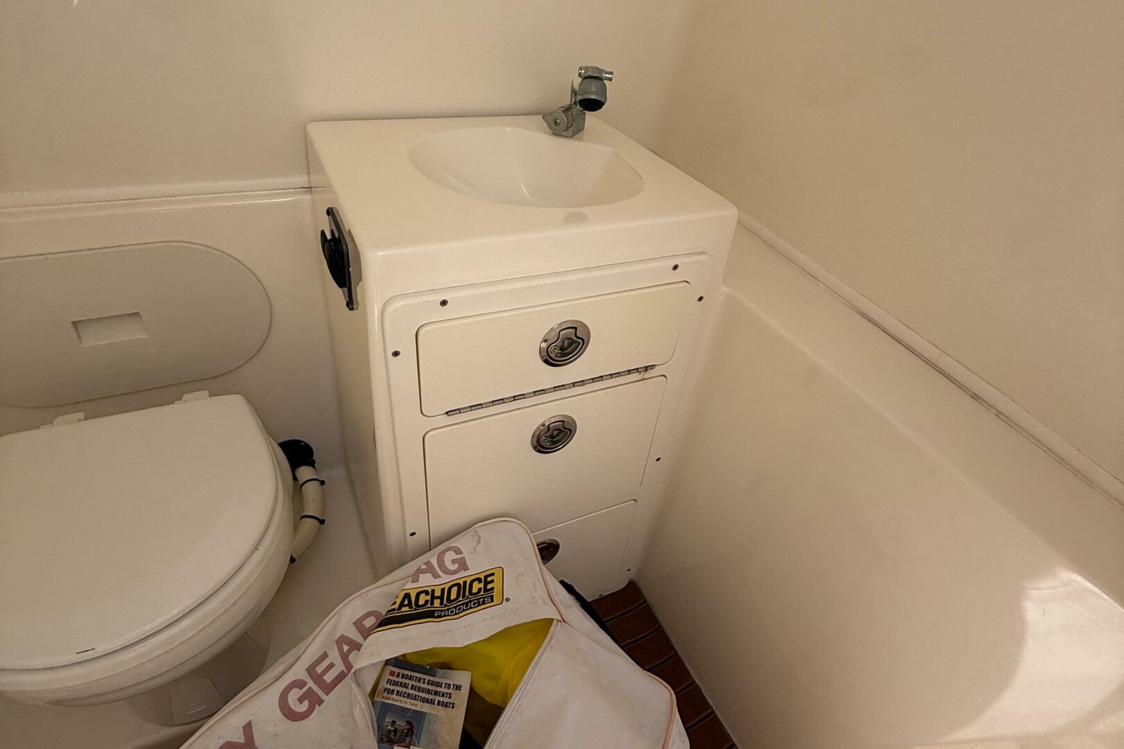 2015 Cobia 296 Center Console boat bathroom with sink and st