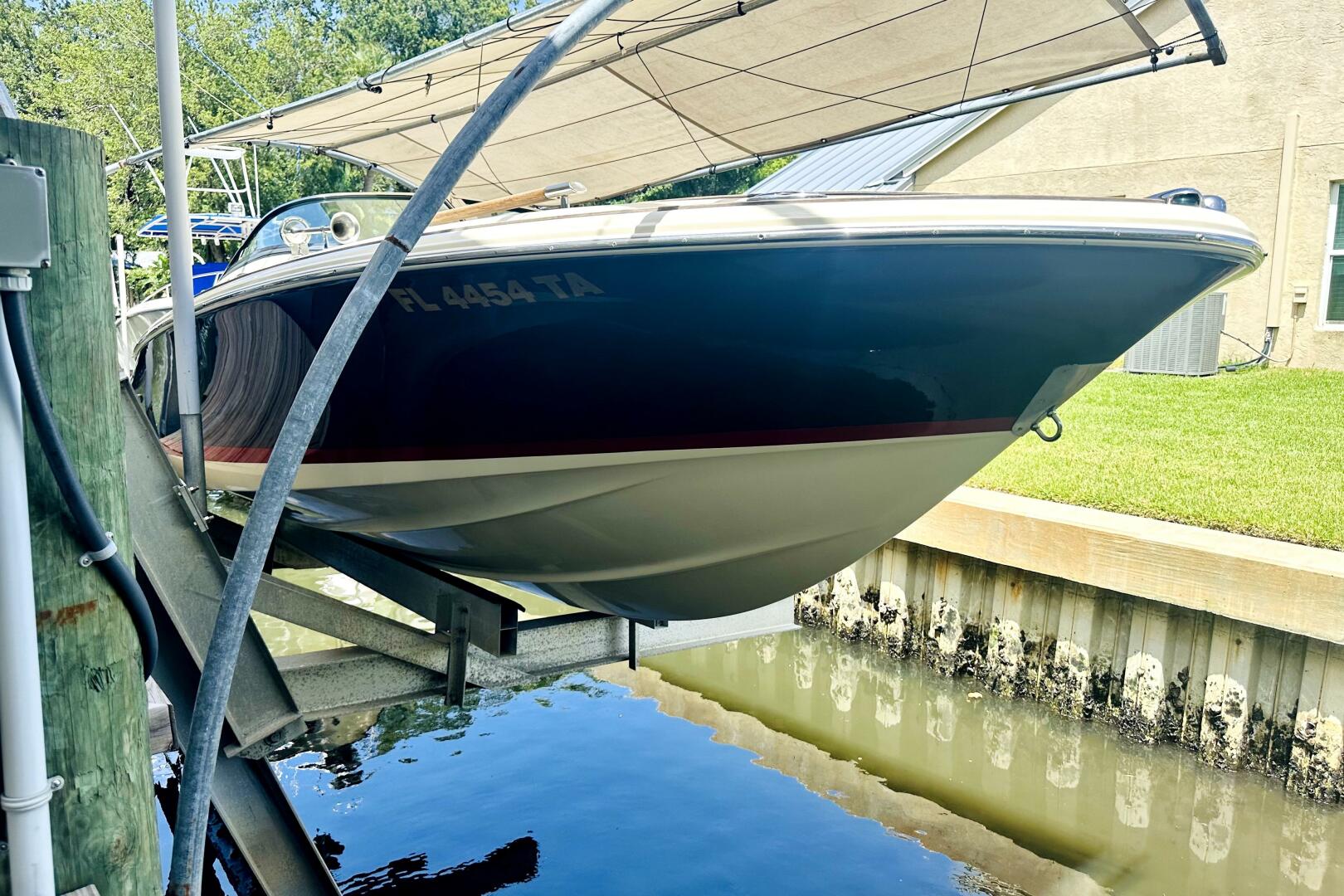 2013 Chris-Craft Corsair 22 boat on lift, docked near water.