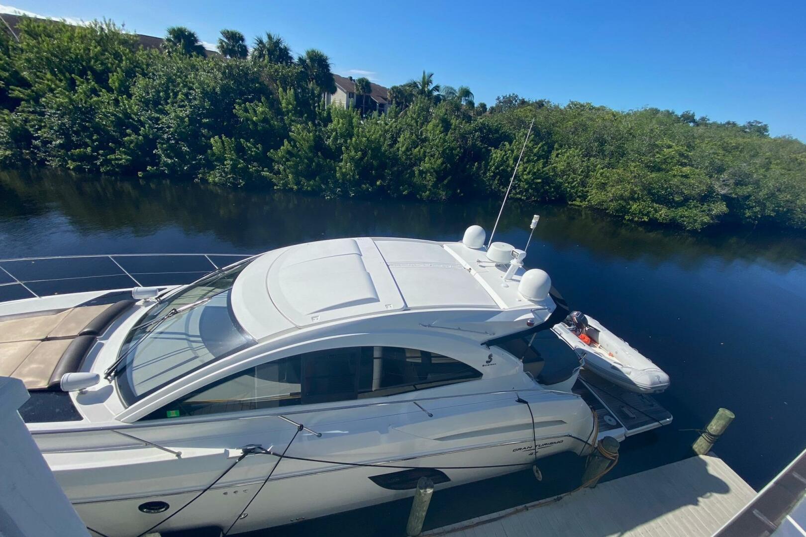 2014 Beneteau Gran Turismo 44 yacht docked by a lush riversi