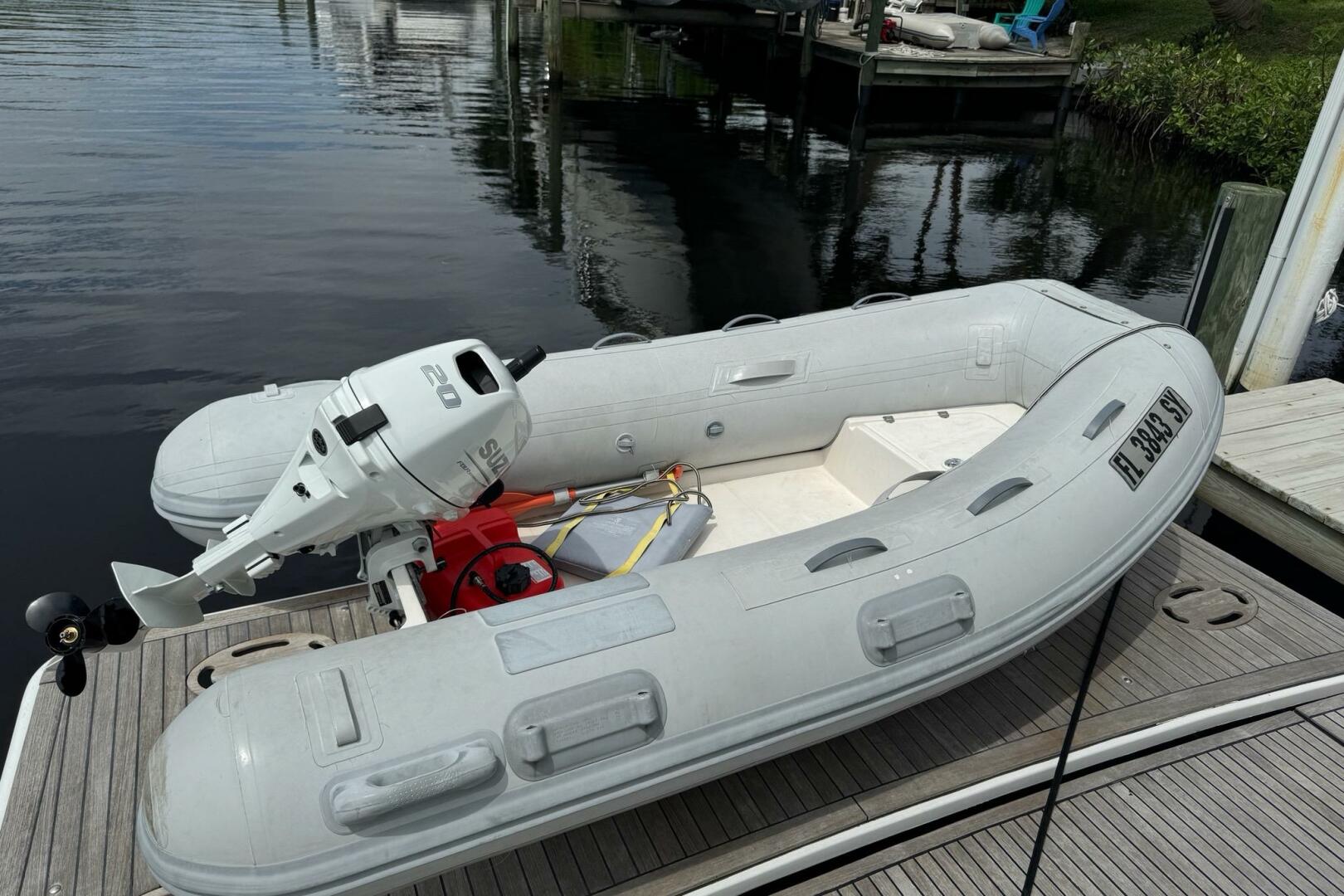 Inflatable boat with outboard motor docked beside a Beneteau
