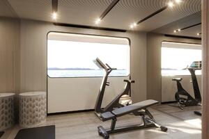 Luxury yacht gym interior with exercise bikes and bench, Maj