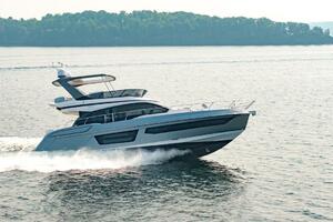 2023 Azimut Fly 53 yacht cruising on a serene lake with lush