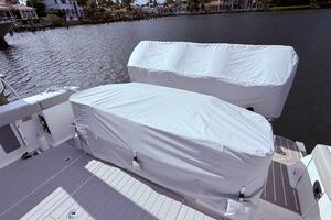 2024 Scout 400 LXF boat with covered engines docked by waterfront homes.