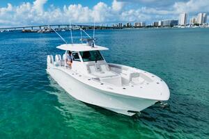 2024 Scout 400 LXF boat cruising on clear blue water near a city skyline.
