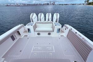 2024 Scout 400 LXF boat deck with four engines, overlooking a scenic waterfront.