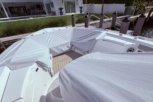 2024 Scout 400 LXF boat covered at dockside near modern waterfront home.
