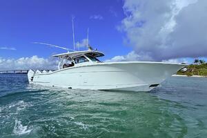 2024 Scout 400 LXF boat on clear blue water under a bright sky.