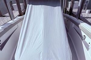 2024 Scout 400 LXF boat with covered console, docked under cloudy skies.