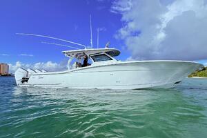 2024 Scout 400 LXF boat on clear water under a blue sky.