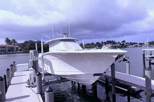 2024 Scout 400 LXF boat docked at marina under cloudy sky.