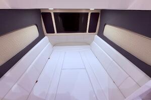 Luxurious interior cabin of 2024 Scout 400 LXF boat with white seating.