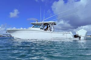 2024 Scout 400 LXF boat on water under blue sky.