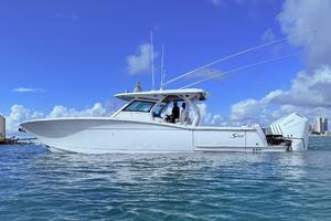 2024 Scout 400 LXF boat on water under clear blue sky.