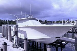 2024 Scout 400 LXF boat docked at marina under cloudy sky.
