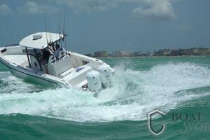 2022 CG Boat Works 35 M-Series navigating choppy waters near a coastal city.
