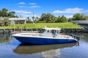 2015 Yellowfin 39 boat on calm water near a grassy shoreline