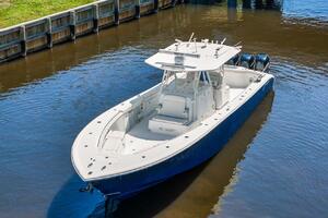 2015 Yellowfin 39 boat on calm water near a wooden dock.