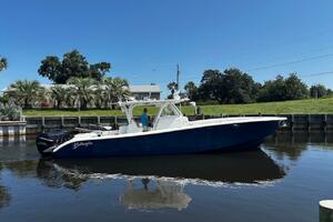 2015 Yellowfin 39 boat on calm water, clear sky, and lush gr