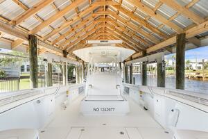 2015 Yellowfin 39 boat docked under wooden shelter by the wa