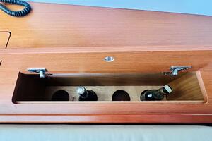 Wooden storage compartment with bottles on a 2015 Beneteau O