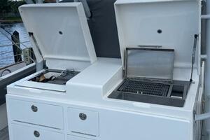2018 Regulator 41 boat with open storage compartments and grill on deck.
