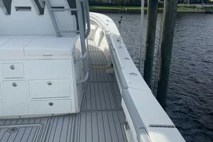 2018 Regulator 41 boat docked by waterfront homes, featuring spacious deck and modern design.