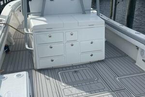 2018 Regulator 41 boat deck with storage compartments and seating, docked by waterfront homes.