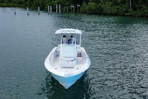 2023 Contender 24 Sport boat on calm water, surrounded by lu