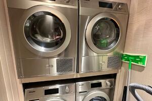 Stacked Miele laundry machines in a compact space, featuring