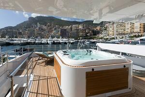 Luxury yacht Majesty 140 with jacuzzi, docked in a scenic ma