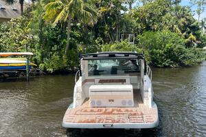2025 Real 40 HT Luxury boat cruising on a scenic river with lush greenery.