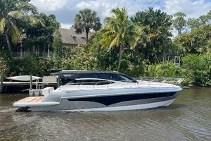 2025 Real 40 HT Luxury yacht cruising on a scenic river with lush greenery.