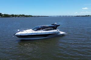 2025 Real 40 HT Luxury yacht cruising on a calm river under a clear blue sky.