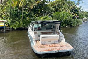 Luxury 2025 Real 40 HT boat on a serene river, surrounded by lush greenery.